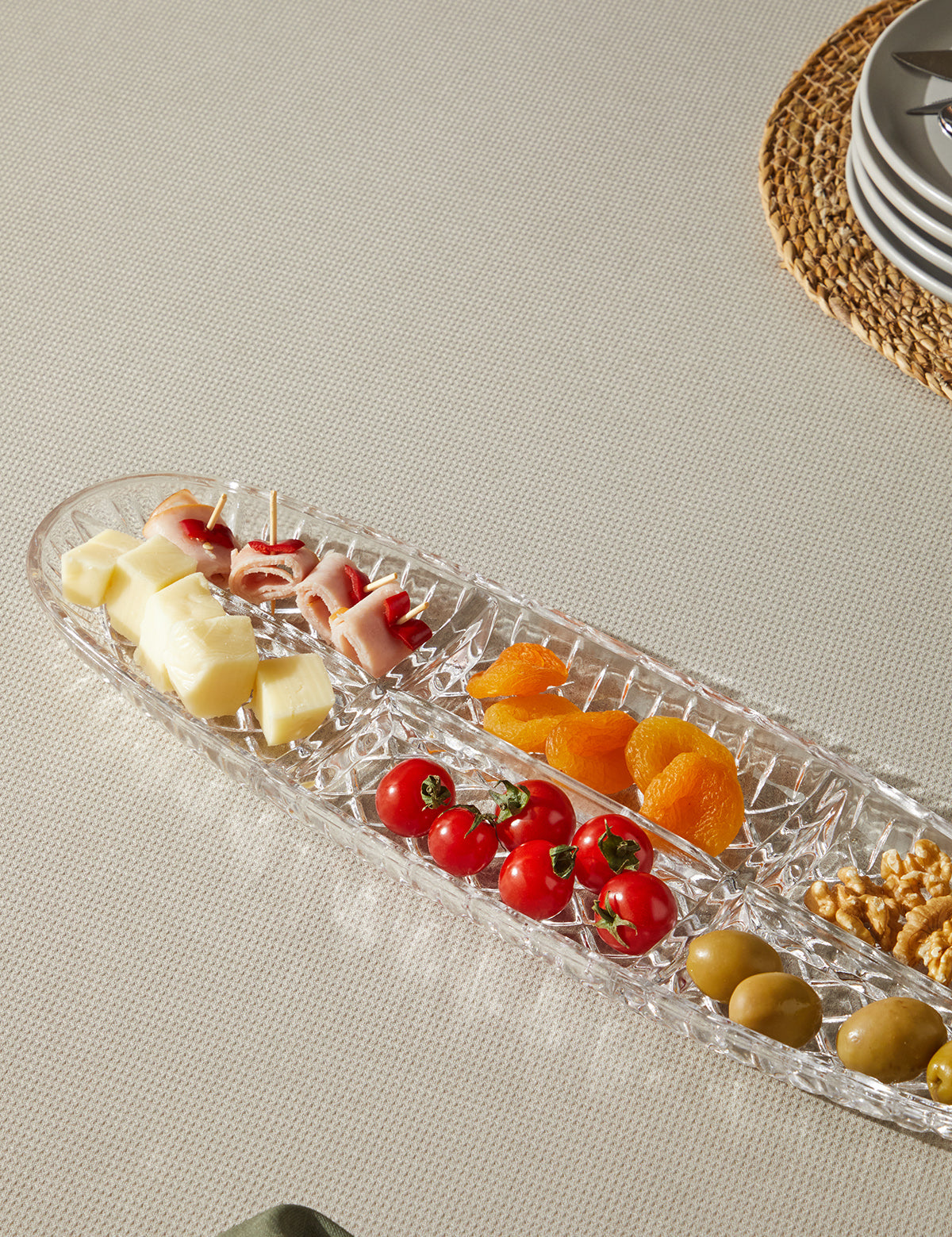 Farklı meyve ve aperatifler ile dolu Glamis Cam Kafes Model 6 Bölme Kayık Tabak, modern bir masa düzeni sunuyor.