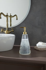 Glamis İdil Model Sıvı Sabunluk, modern tasarım ile el yapımı camın zarif birleşimi, banyo masasında yer almakta. Geniş hacmiyle pratik kullanım sunarak banyonuzda şıklık yaratır.